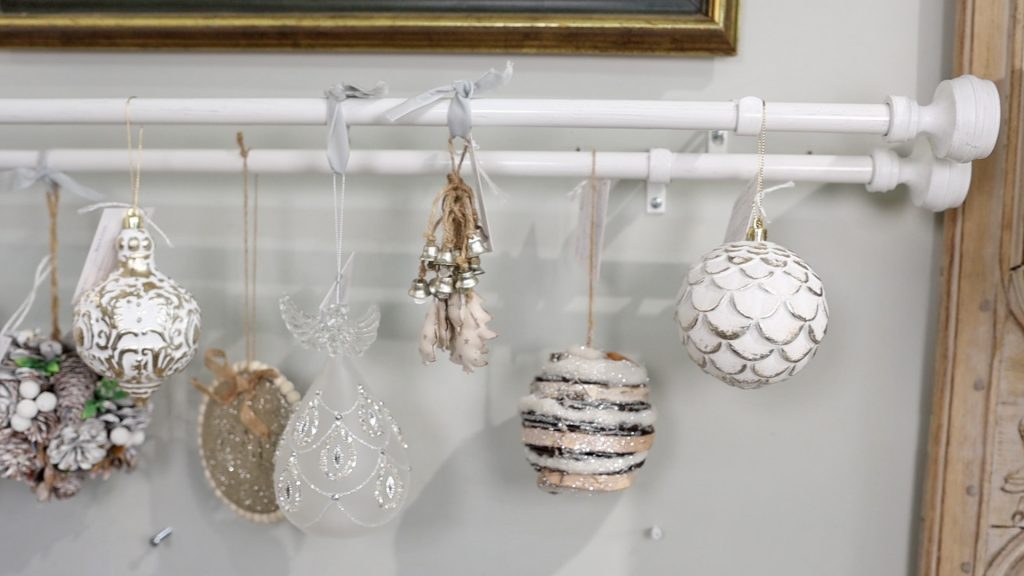 To make use out of Christmas ornaments without a tree, Amitha Verma creates an effect of staggering ornaments on curtain rods to create a window display. 